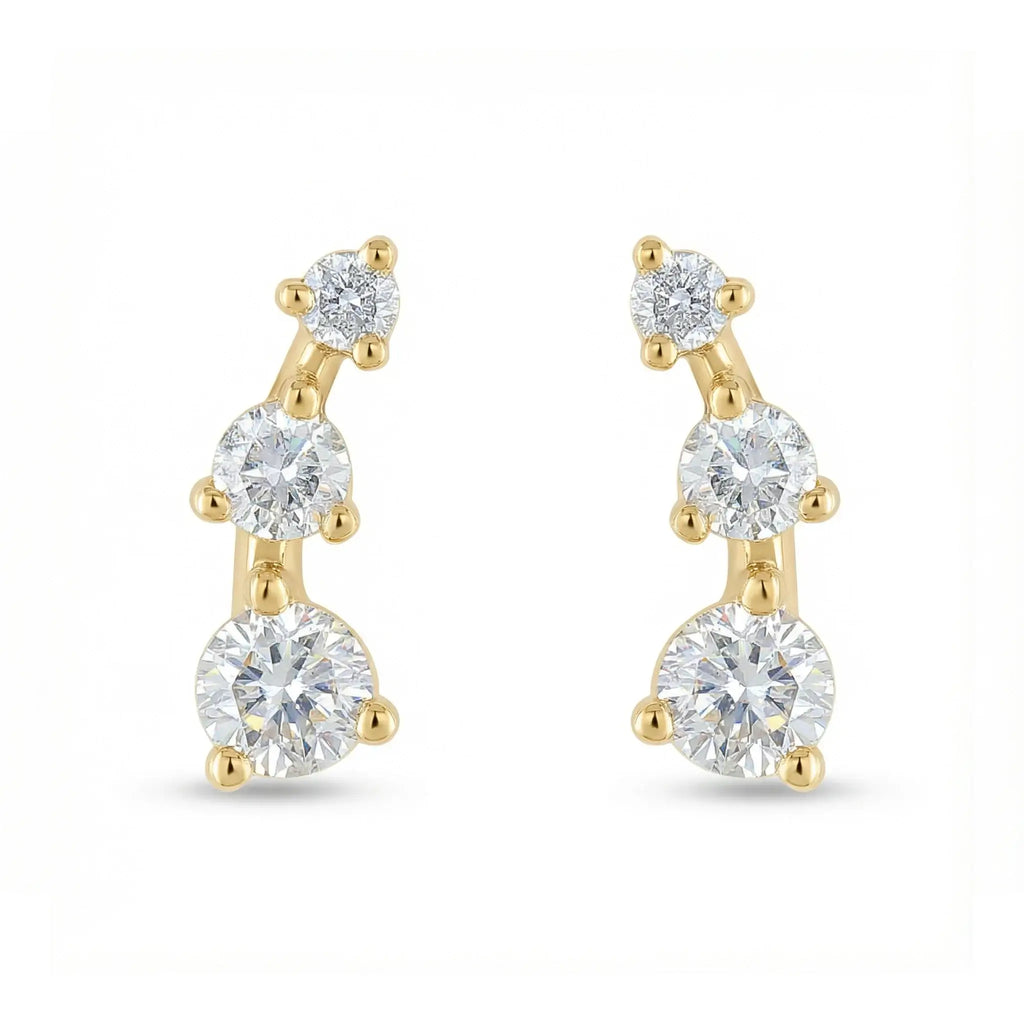 A sleek 14K yellow gold ear crawler earring, featuring three round brilliant diamonds set in a straight, minimalist line that ascends the earlobe.