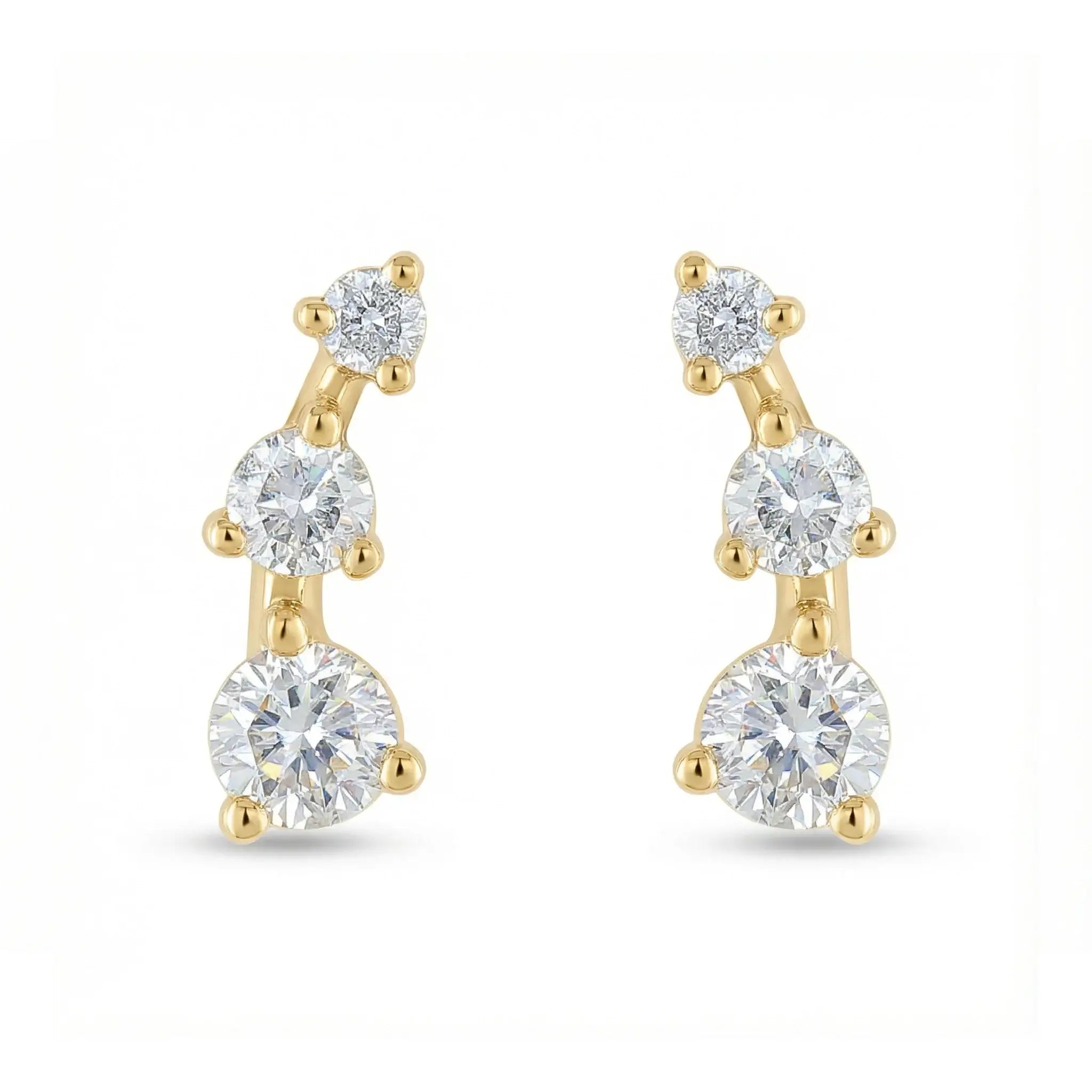 A sleek 14K yellow gold ear crawler earring, featuring three round brilliant diamonds set in a straight, minimalist line that ascends the earlobe.