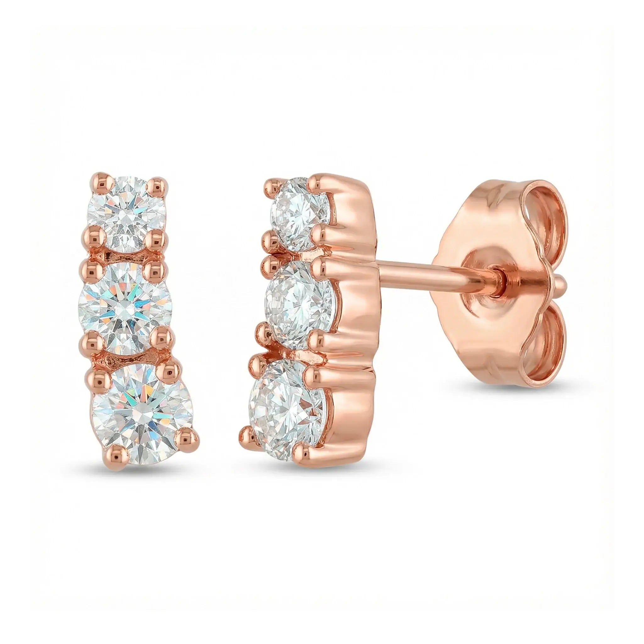 A pair of classic 14K rose gold stud earrings, each featuring three round brilliant diamonds set in a horizontal row, symbolizing timeless elegance.