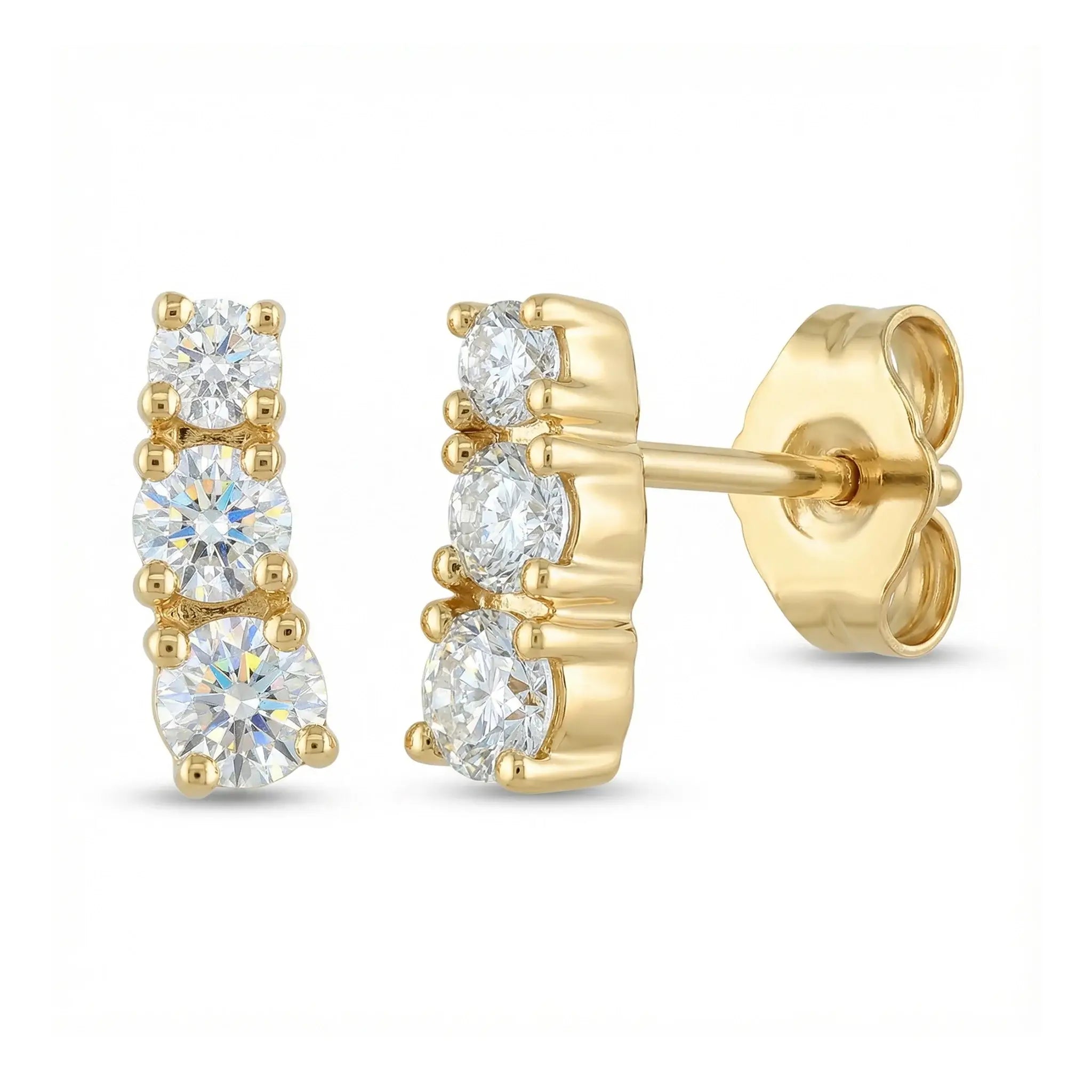 A pair of classic 14K yellow gold stud earrings, each featuring three round brilliant diamonds set in a horizontal row, symbolizing timeless elegance.