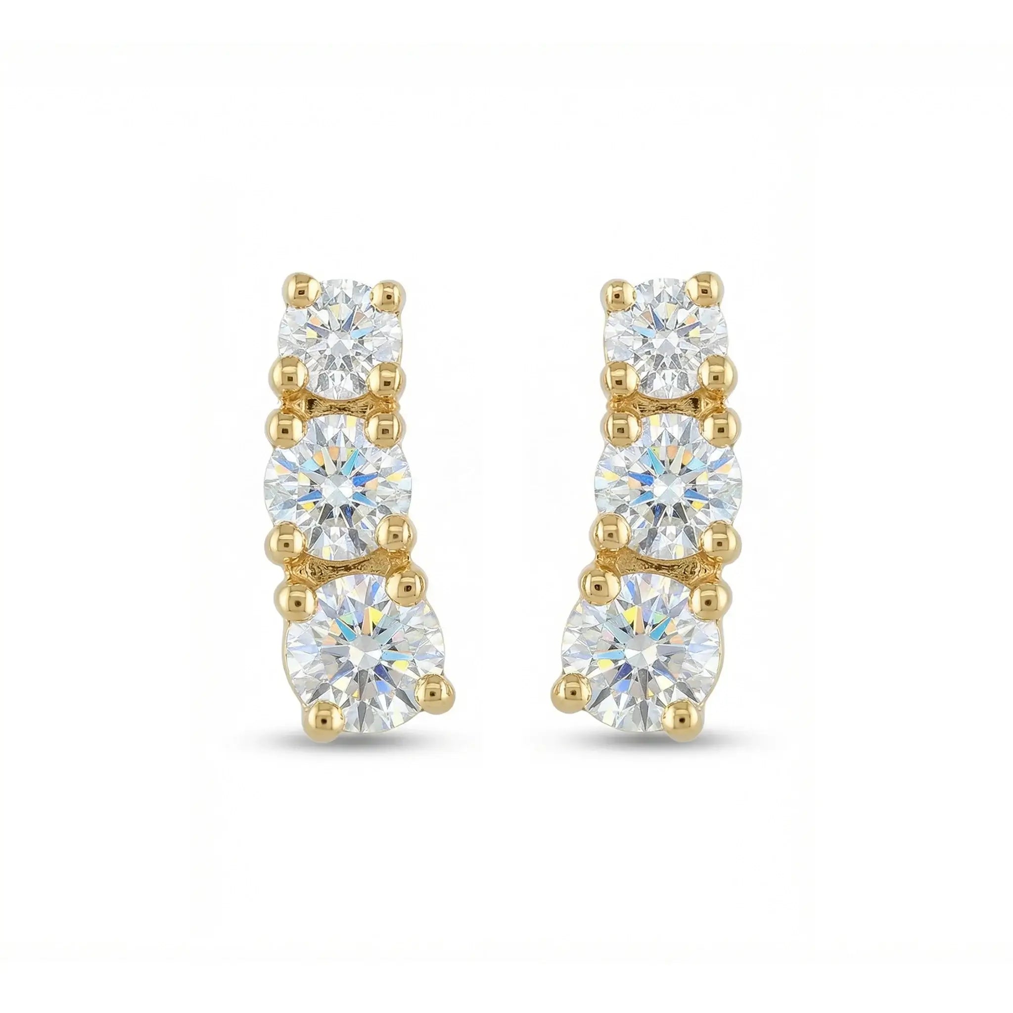 A pair of classic 14K yellow gold stud earrings, each featuring three round brilliant diamonds set in a horizontal row, symbolizing timeless elegance.
