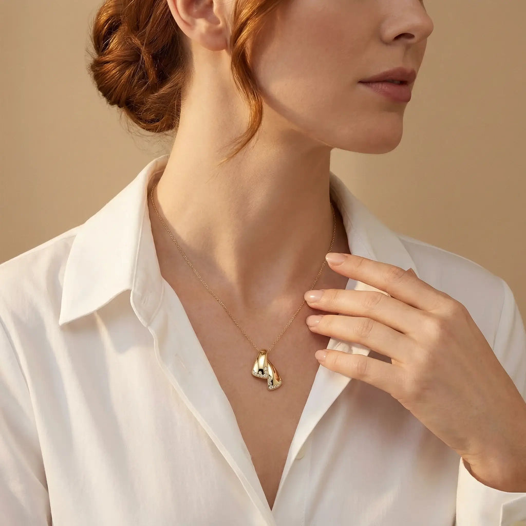 Woman wearing a 14K Yellow Gold Diamond Strada Pendant - Front View against a beige background