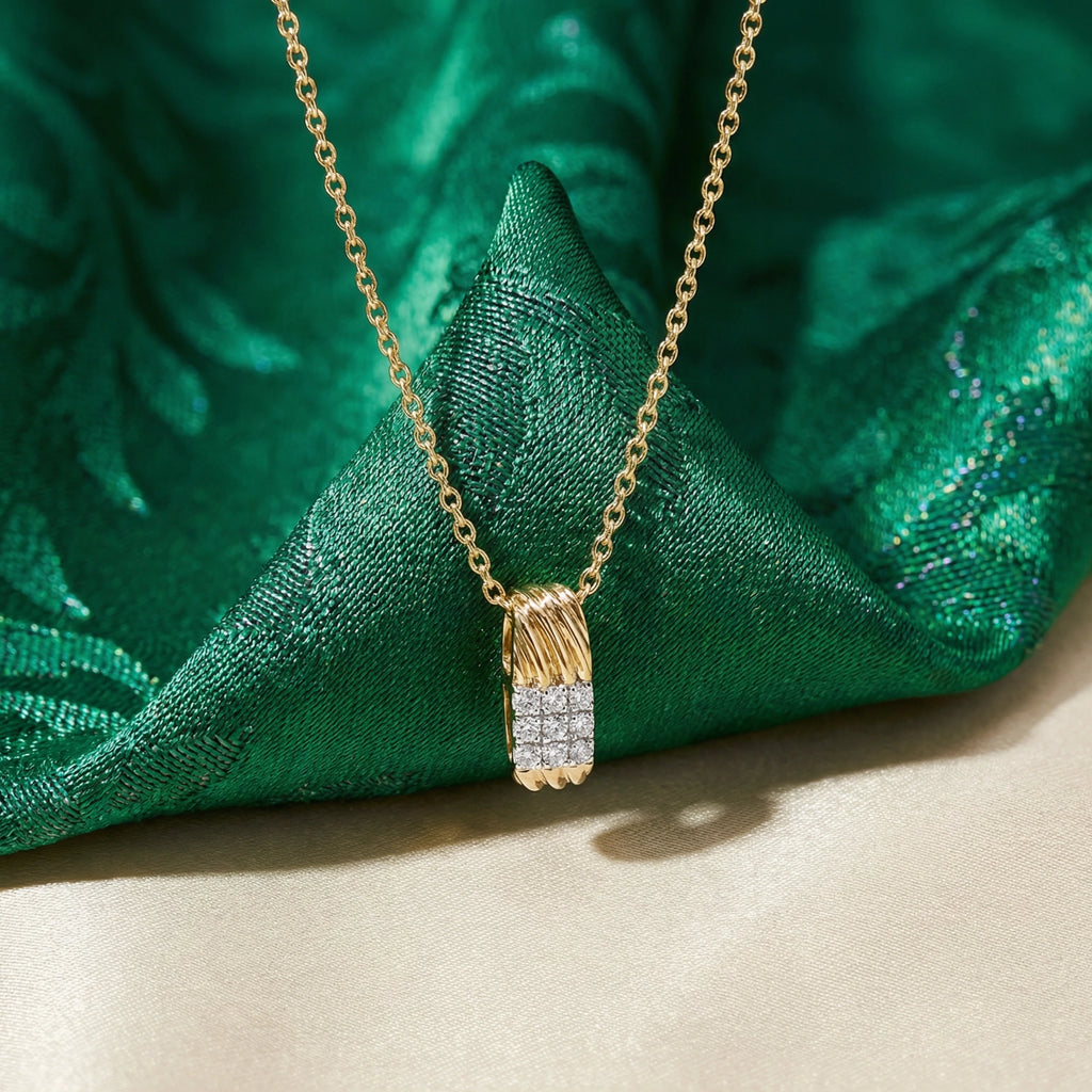 Gold necklace with a diamond pendant on green fabric