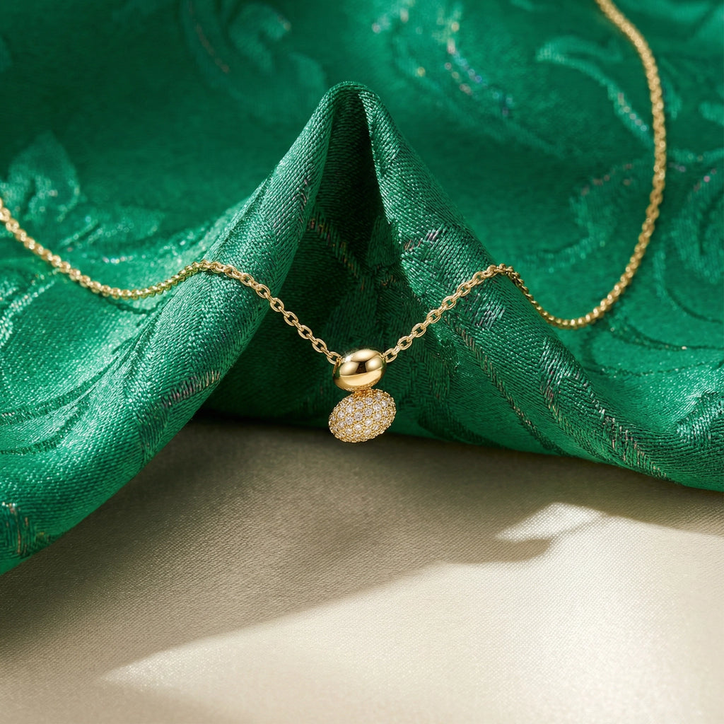 Gold necklace with a pendant on green fabric