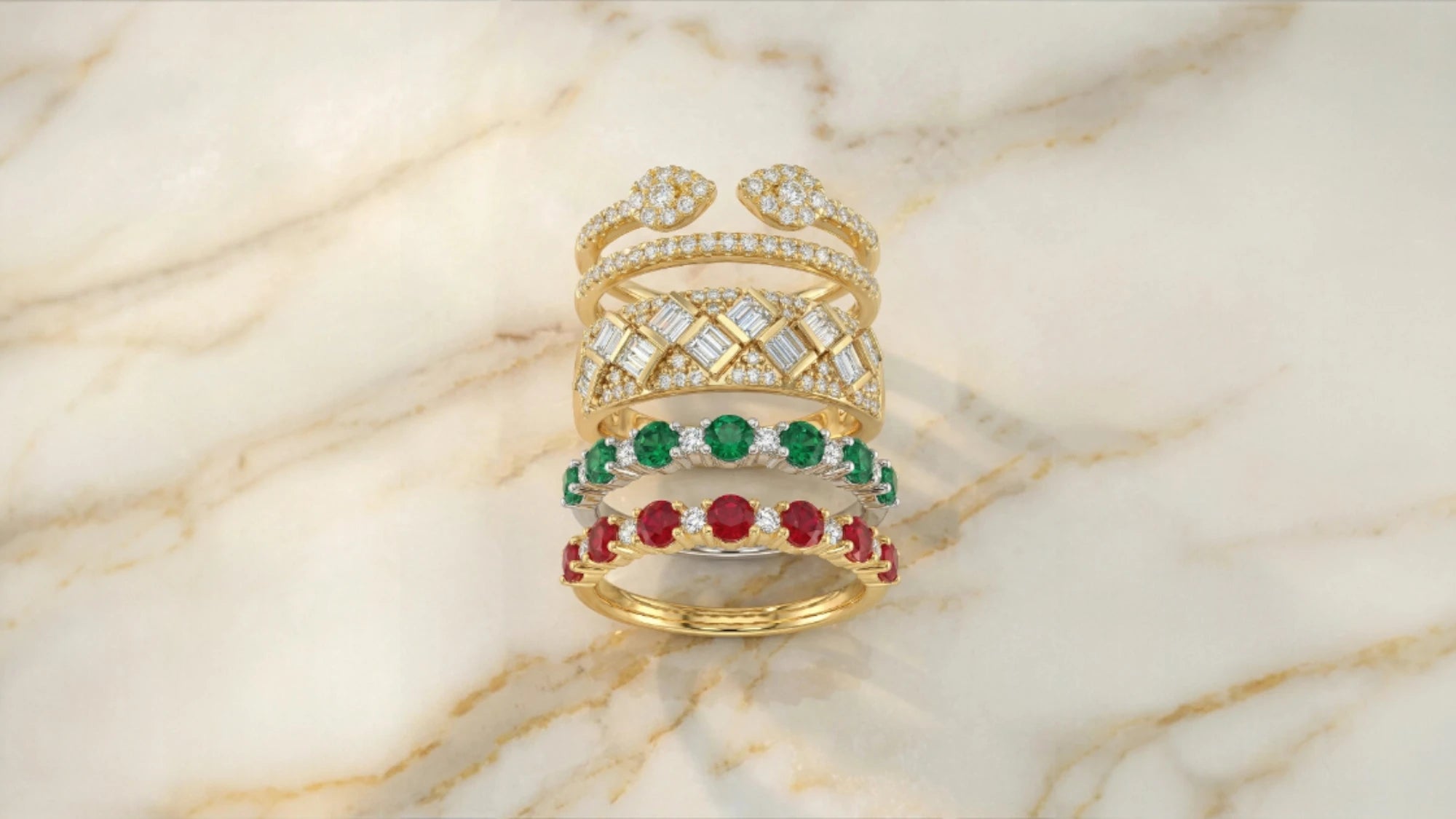 Set of gold rings with gemstones on a marble surface
