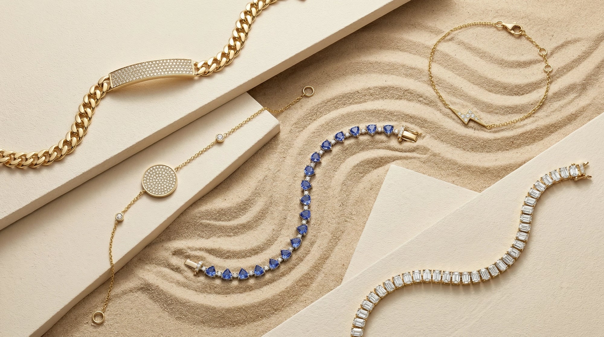 A curated flat lay of BeBling bracelets including a diamond line tennis bracelet, a paperclip chain, and a delicate charm bracelet, ready for stacking.