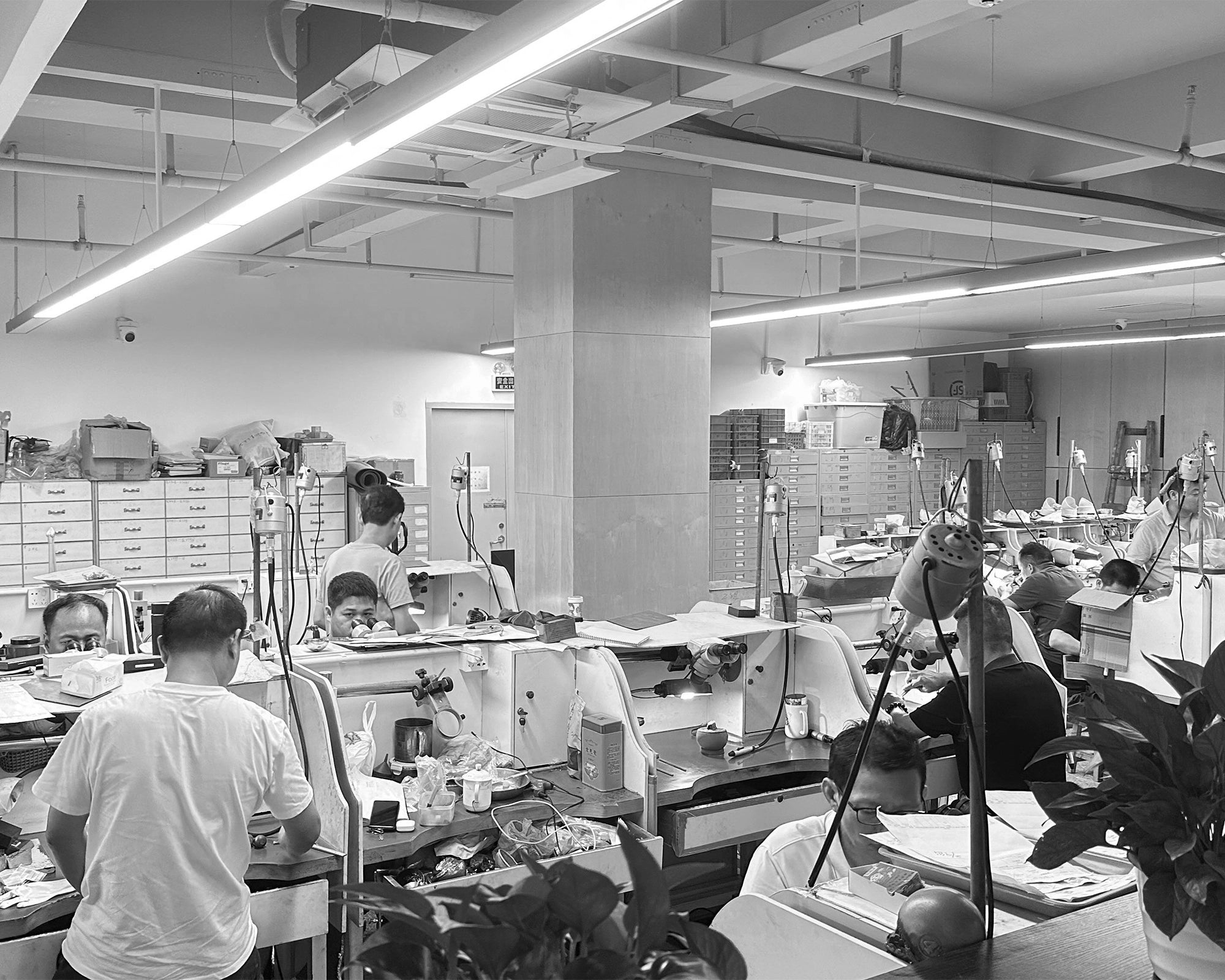 A master jeweler at our factory meticulously setting a brilliant-cut natural diamond into a 14k gold engagement ring, showcasing our commitment to fine craftsmanship.