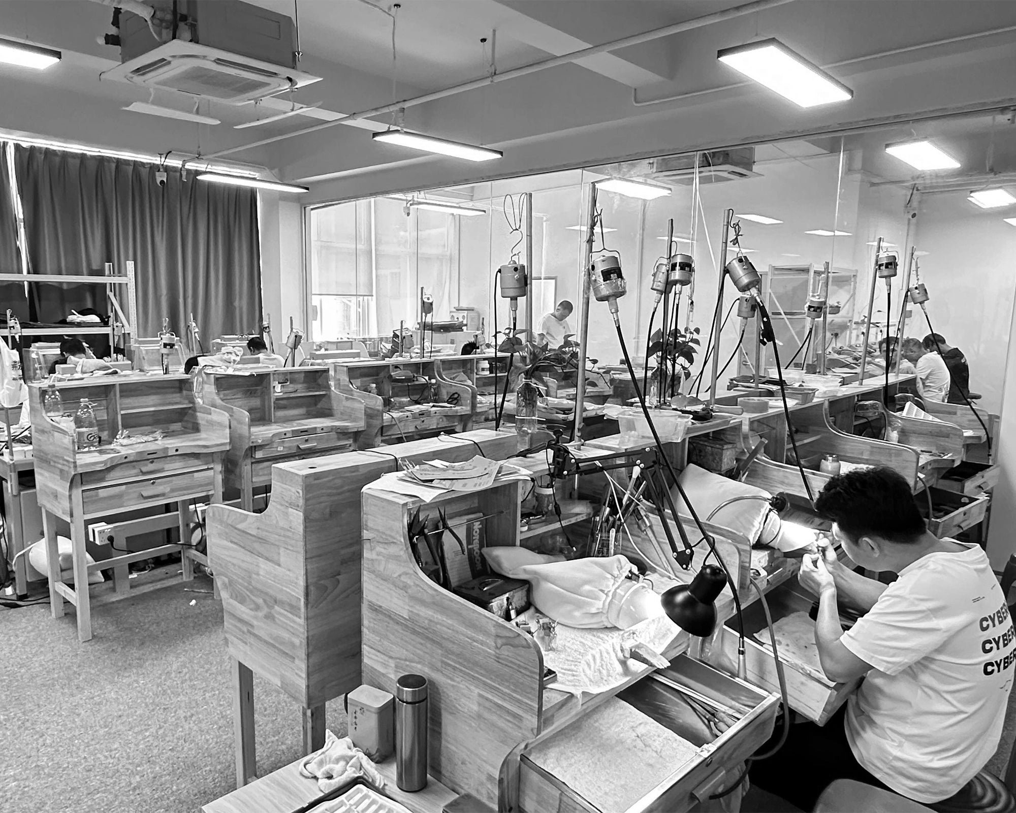 A master jeweler at our factory meticulously setting a brilliant-cut natural diamond into a 14k gold engagement ring, showcasing our commitment to fine craftsmanship.