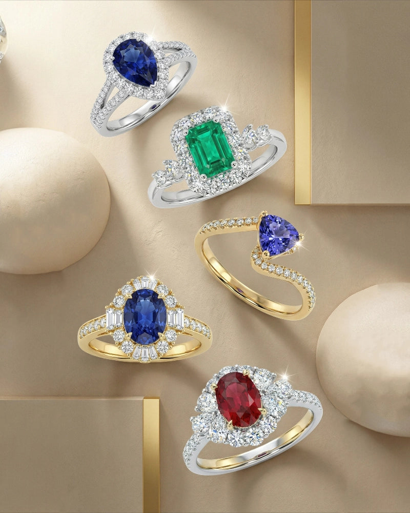 Collection of gemstone rings on a beige background